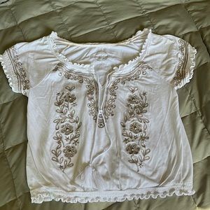 Cute cap sleeve shirt sleeve top. Gold applique and studs on front of shirt